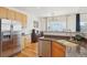 Well-lit kitchen featuring stainless steel appliances, granite countertops, and wood cabinetry at 16665 Kenuil St, Brighton, CO 80603