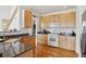 Functional kitchen featuring wood cabinets, granite countertops, and hardwood floors at 16665 Kenuil St, Brighton, CO 80603