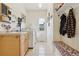 Bright laundry room featuring a sink, cabinets, modern washer and dryer, bench, and storage hooks at 16665 Kenuil St, Brighton, CO 80603