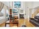 Inviting living room with high ceilings, a cozy fireplace, large windows, and comfortable leather sofas at 16665 Kenuil St, Brighton, CO 80603