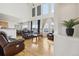 Bright living room with hardwood floors, tall windows, and comfortable leather seating creating a welcoming atmosphere at 16665 Kenuil St, Brighton, CO 80603