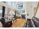 Bright living room with soaring ceilings, a cozy fireplace, large windows, and comfortable leather sofas at 16665 Kenuil St, Brighton, CO 80603