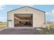 The outbuilding's interior is a workshop and parking for cars and equipment at 16665 Kenuil St, Brighton, CO 80603