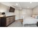 Neutral bedroom features a modern dresser, wall-mounted television and plush carpeting at 4997 Collinsville Pl, Highlands Ranch, CO 80130