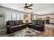 Open-concept living room with comfortable sofas, ceiling fan, and seamless flow into the kitchen at 4997 Collinsville Pl, Highlands Ranch, CO 80130