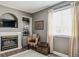 Comfortable living room with a cozy fireplace, built-in shelving, and natural light at 4997 Collinsville Pl, Highlands Ranch, CO 80130