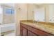 Updated bathroom featuring a granite vanity and tiled shower-tub at 72 S Nome St, Aurora, CO 80012