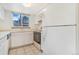 The kitchen features white appliances, cabinets, countertops, and a window view at 72 S Nome St, Aurora, CO 80012