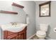 Charming powder room with wood-trimmed mirror and vanity, and chrome fixtures at 10212 Kelliwood Way, Highlands Ranch, CO 80126