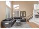 Comfortable living area with hardwood flooring, a gray sectional sofa, and a large window at 10212 Kelliwood Way, Highlands Ranch, CO 80126