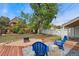 Inviting backyard featuring wood deck, gravel, blue Adirondack chairs, and partial view of the home at 1691 Roslyn St, Denver, CO 80220