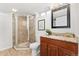 Well-lit bathroom features a stand up shower with glass door, granite countertop and a stylish mirror at 1691 Roslyn St, Denver, CO 80220