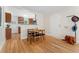 Dining room with wood floors opens to kitchen with wood cabinets and stainless appliances at 1691 Roslyn St, Denver, CO 80220