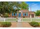 Charming brick home features a well-manicured lawn and delightful white picket fence, and eye-catching blue shutters and front door at 1691 Roslyn St, Denver, CO 80220