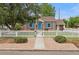 Charming brick home with bright blue door, shutters and white picket fence at 1691 Roslyn St, Denver, CO 80220