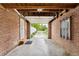 Exposed brick in the garage, featuring an open door and concrete floor at 1691 Roslyn St, Denver, CO 80220