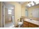 Bathroom featuring oak vanity, tile backsplash and direct access to laundry room at 13313 Elizabeth St, Thornton, CO 80241