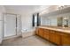 Bright bathroom featuring dual sinks, oak cabinets, soaking tub and separate shower enclosure at 13313 Elizabeth St, Thornton, CO 80241