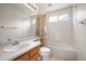 Bright secondary bathroom with tiled shower over tub and oak vanity at 13313 Elizabeth St, Thornton, CO 80241