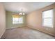 Cozy dining room featuring neutral walls, plush carpet, a large window, and a stylish chandelier at 13313 Elizabeth St, Thornton, CO 80241