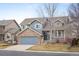 Charming two-story home featuring blue siding, brick accents, a covered porch, and a well-manicured front yard at 13313 Elizabeth St, Thornton, CO 80241