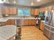 Well-lit kitchen with stainless steel appliances, wooden cabinets, and a view to the backyard at 13313 Elizabeth St, Thornton, CO 80241