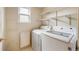 Functional laundry area with washer, dryer, and shelving providing plenty of storage space at 13313 Elizabeth St, Thornton, CO 80241