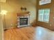 Inviting living room featuring hardwood floors, a brick fireplace, and plenty of natural light at 13313 Elizabeth St, Thornton, CO 80241