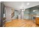 Open-concept living space with hardwood floors, a staircase, and a view into an adjacent living space at 13313 Elizabeth St, Thornton, CO 80241