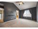 Vaulted ceiling primary bedroom featuring dark accent wall, neutral carpeting, and attached bath at 13313 Elizabeth St, Thornton, CO 80241