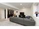 Finished basement with a comfortable gray sectional sofa, entertainment center, and a bookcase with shelving at 7167 Hyland Hills St, Castle Pines, CO 80108
