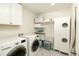 Bright laundry room featuring a washer and dryer, shelving, storage, and modern fixtures for a functional space at 7167 Hyland Hills St, Castle Pines, CO 80108