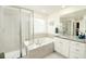 Spa-like main bathroom with a soaking tub, separate glass shower, and a vanity with granite countertops at 7167 Hyland Hills St, Castle Pines, CO 80108