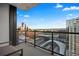 Balcony showcasing a stunning cityscape view with glass railings and an outdoor seating area at 1750 Wewatta St # 1720, Denver, CO 80202