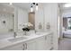 Modern bathroom with double vanity, white cabinets, and marble shower through the bedroom's walk-in closet at 1750 Wewatta St # 1720, Denver, CO 80202