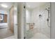 Modern bathroom with a glass enclosed shower, marble tile, and a view to the bedroom at 1750 Wewatta St # 1720, Denver, CO 80202