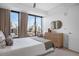 Serene bedroom featuring city views through a large window, complemented by neutral tones and modern furnishings at 1750 Wewatta St # 1720, Denver, CO 80202
