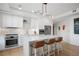 Bright white kitchen with stainless steel appliances, modern lighting, and an island with barstool seating at 1750 Wewatta St # 1720, Denver, CO 80202