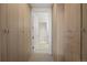 Bright walk-in closet with light wood cabinetry and a view into the ensuite bathroom at 1750 Wewatta St # 1720, Denver, CO 80202