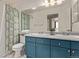 Charming bathroom features blue vanity, double sinks, and a tub with decorative shower curtain at 5079 Morning Glory Pl, Highlands Ranch, CO 80130