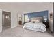 A charming bedroom with blue accent wall, plush carpeting and neutral finishes at 5079 Morning Glory Pl, Highlands Ranch, CO 80130