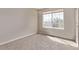 Sunlit bedroom with neutral walls and plush carpeting and a large window at 5079 Morning Glory Pl, Highlands Ranch, CO 80130