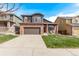 The brick and siding exterior highlights a paved driveway leading to an attached garage and manicured landscaping at 5079 Morning Glory Pl, Highlands Ranch, CO 80130