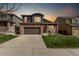 Charming two-story home featuring a brick facade, well-manicured lawn, and a two-car garage at 5079 Morning Glory Pl, Highlands Ranch, CO 80130