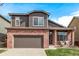 Two-story brick home with a well-maintained lawn and inviting front porch seating at 5079 Morning Glory Pl, Highlands Ranch, CO 80130