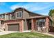 Charming home with a well-maintained lawn, and brick accents, complemented by lush greenery and ample natural light at 5079 Morning Glory Pl, Highlands Ranch, CO 80130