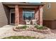 Close-up of a welcoming front porch with brick columns and decorative landscaping at 5079 Morning Glory Pl, Highlands Ranch, CO 80130