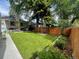 Large backyard features a lush green lawn, stained fence, covered patio, landscaping, and a grill at 386 Colorado Blvd, Denver, CO 80206