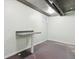 Unfinished basement offers potential for customization with concrete floors and a small wall-mounted table at 386 Colorado Blvd, Denver, CO 80206