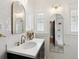 Bright bathroom featuring white subway tile, arched mirrors, and a modern vanity with white countertop and black cabinetry at 386 Colorado Blvd, Denver, CO 80206
